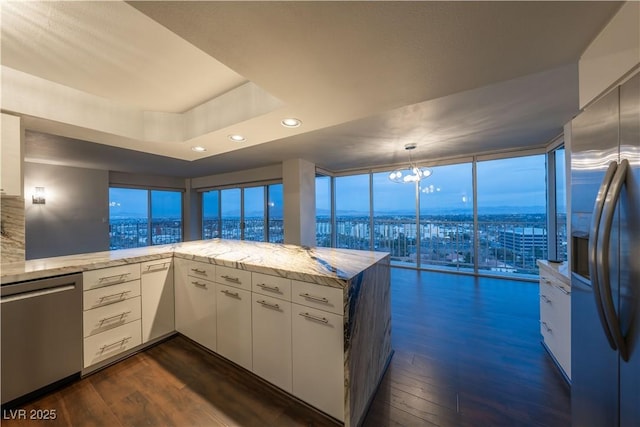 kitchen with white cabinetry, stainless steel appliances, and kitchen peninsula