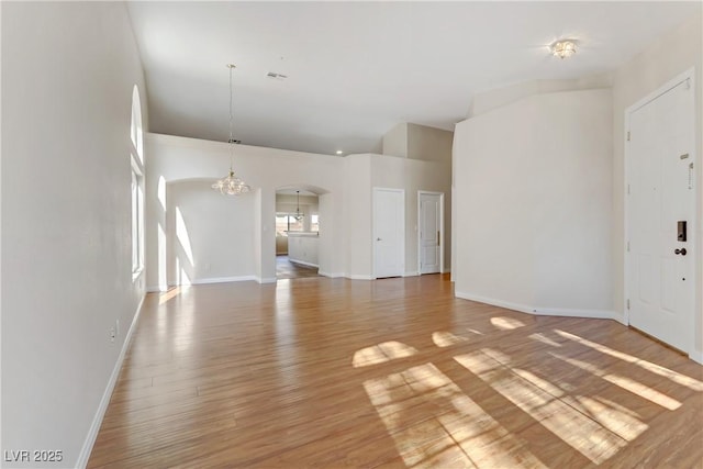 unfurnished living room with hardwood / wood-style flooring and an inviting chandelier