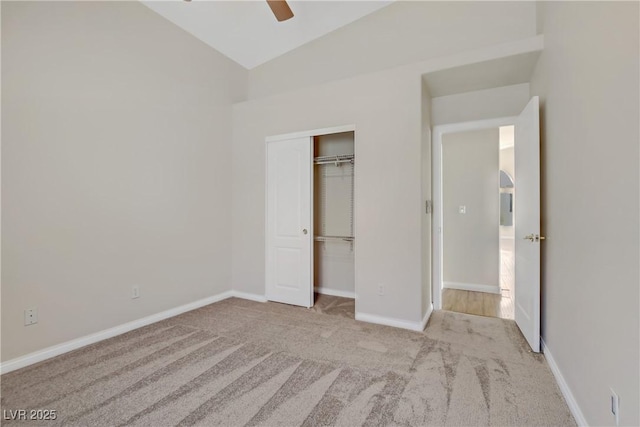 unfurnished bedroom featuring ceiling fan, a closet, lofted ceiling, and light carpet