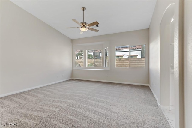 spare room with vaulted ceiling, light colored carpet, and ceiling fan