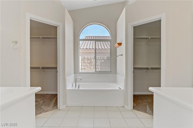 bathroom with a washtub and tile patterned floors