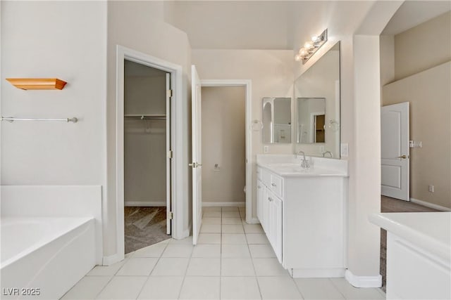 bathroom with tile patterned flooring, vanity, and a washtub