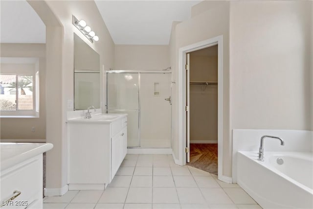 bathroom with tile patterned flooring, vanity, and separate shower and tub