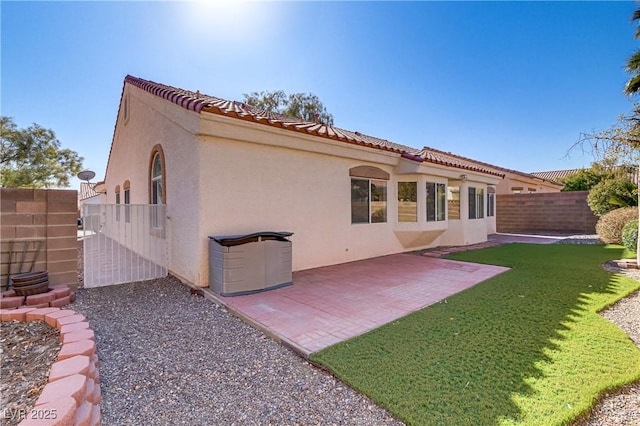 rear view of house with a patio and a lawn