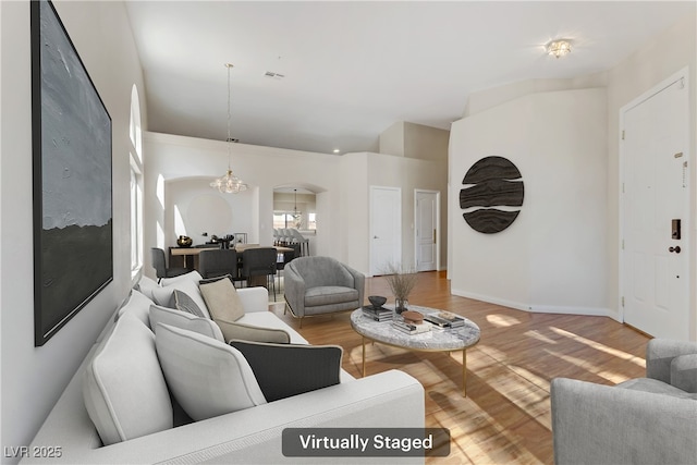 living room featuring an inviting chandelier and hardwood / wood-style floors