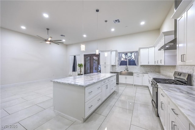 kitchen with sink, white cabinetry, a center island, hanging light fixtures, and appliances with stainless steel finishes