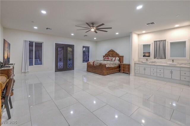 bedroom with sink, connected bathroom, light tile patterned floors, and french doors