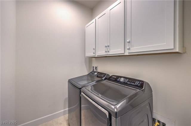 laundry room with cabinets, washing machine and dryer, and light tile patterned floors