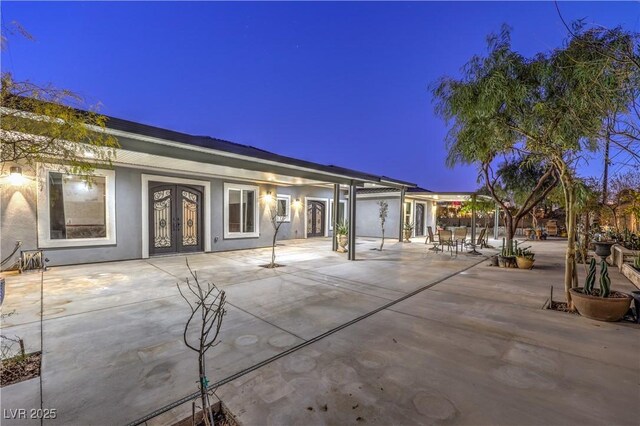 patio terrace at dusk featuring french doors