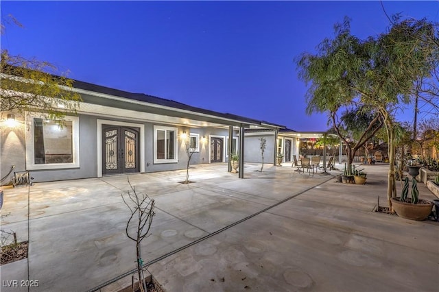 patio terrace at dusk featuring french doors