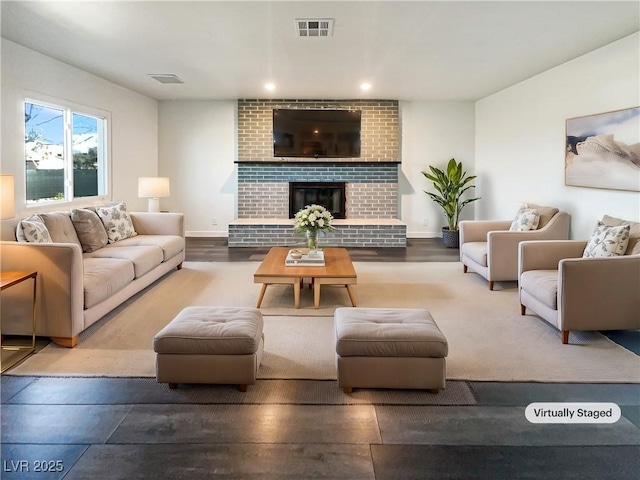 living room with hardwood / wood-style flooring and a brick fireplace