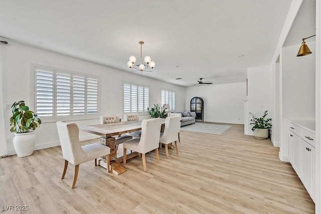 dining space featuring ceiling fan with notable chandelier and light hardwood / wood-style floors