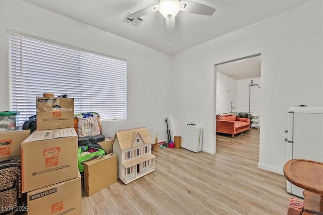 game room with ceiling fan, a healthy amount of sunlight, and light wood-type flooring