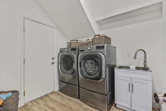 washroom with cabinets, separate washer and dryer, sink, and light hardwood / wood-style flooring