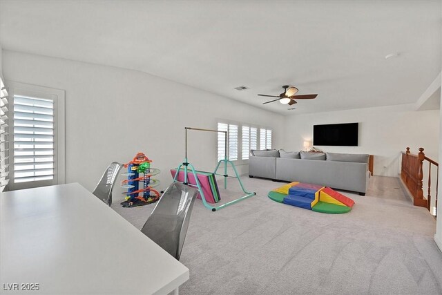 game room with light carpet and ceiling fan