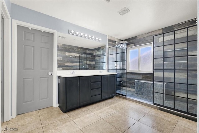 bathroom featuring tiled shower, vanity, and tile patterned floors