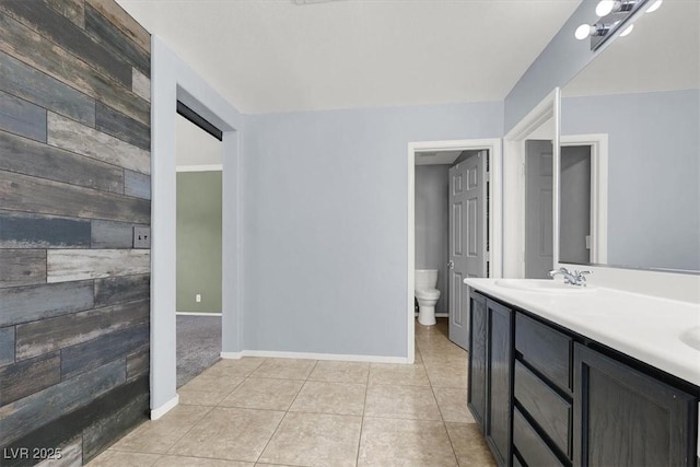 bathroom with tile patterned flooring, vanity, wood walls, and toilet