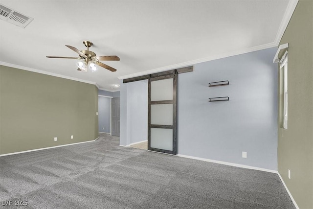 unfurnished room with ornamental molding, a barn door, carpet, and ceiling fan