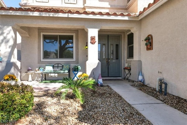 view of exterior entry with a porch