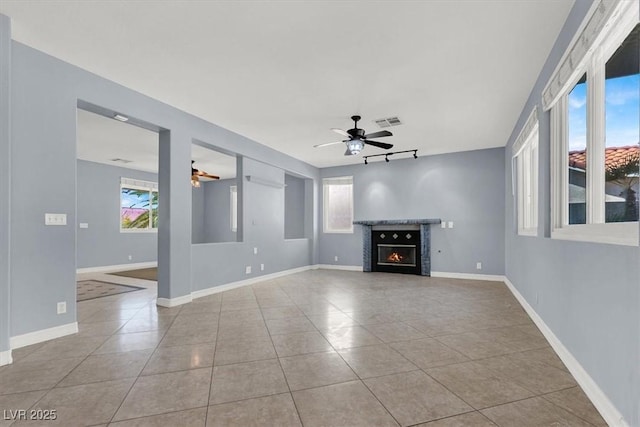 unfurnished living room featuring ceiling fan and light tile patterned flooring