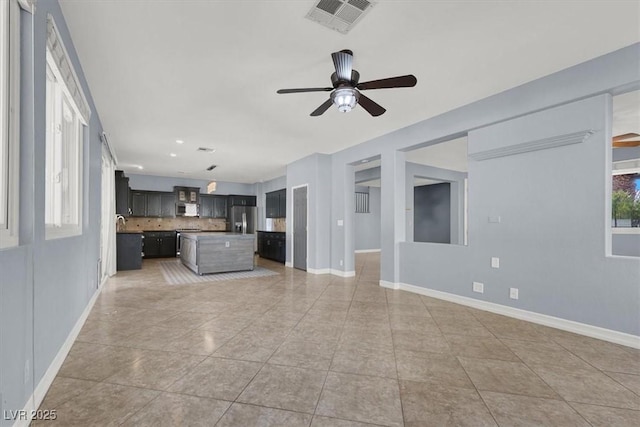 unfurnished living room featuring tile patterned floors and ceiling fan