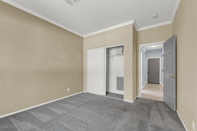 unfurnished bedroom with ornamental molding, carpet floors, and a closet