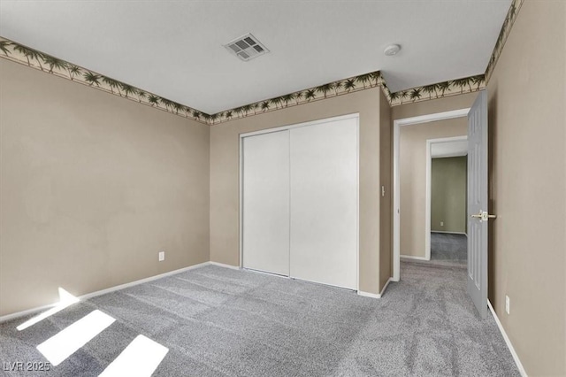 unfurnished bedroom with light carpet and a closet