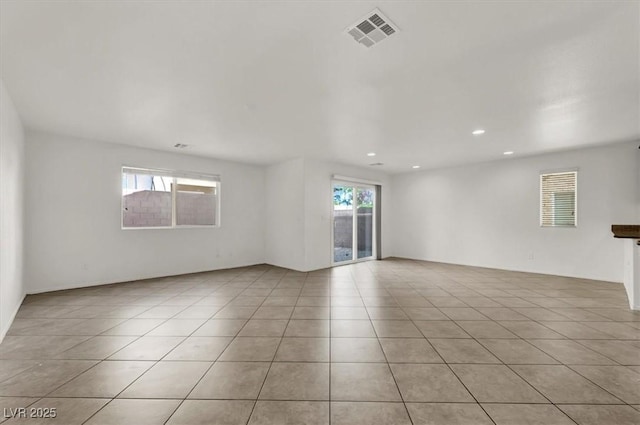 empty room featuring light tile patterned flooring and plenty of natural light