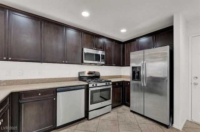 kitchen featuring dark brown cabinets, light tile patterned flooring, and appliances with stainless steel finishes