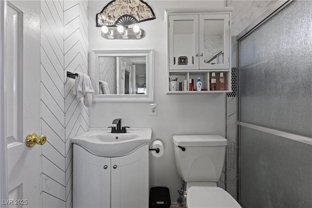 bathroom featuring vanity, an enclosed shower, and toilet