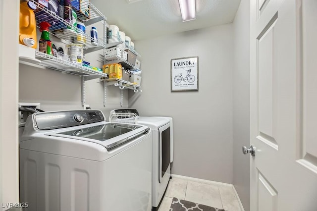 clothes washing area featuring washer and dryer and light tile patterned floors