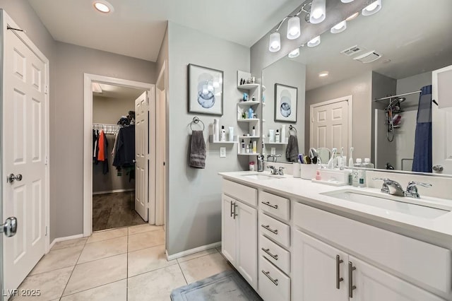 bathroom with tile patterned flooring, vanity, and a shower