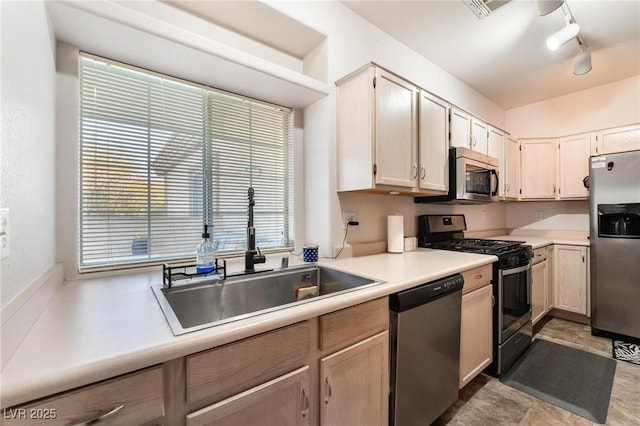 kitchen featuring sink, track lighting, and stainless steel appliances