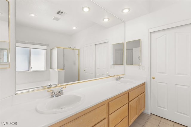 bathroom featuring tile patterned flooring, shower with separate bathtub, and vanity