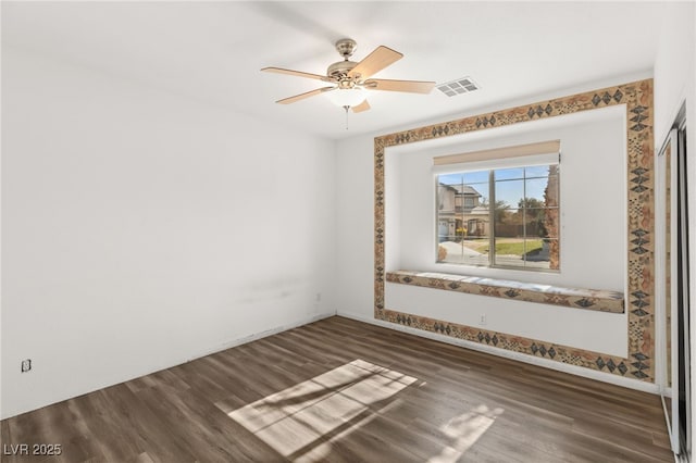 spare room featuring ceiling fan and dark hardwood / wood-style flooring