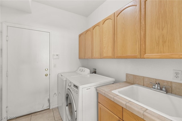 laundry room featuring cabinets, washing machine and dryer, sink, and light tile patterned flooring