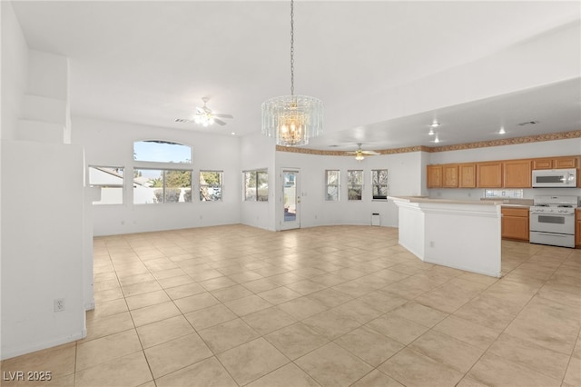 kitchen featuring decorative light fixtures, light tile patterned floors, a kitchen island, white appliances, and ceiling fan with notable chandelier