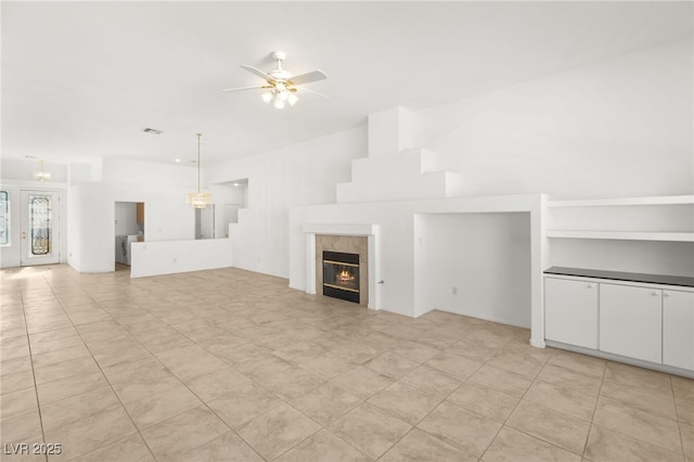 unfurnished living room with ceiling fan and a fireplace