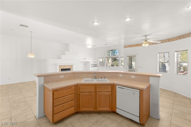 kitchen featuring white dishwasher, sink, a kitchen island with sink, and a healthy amount of sunlight