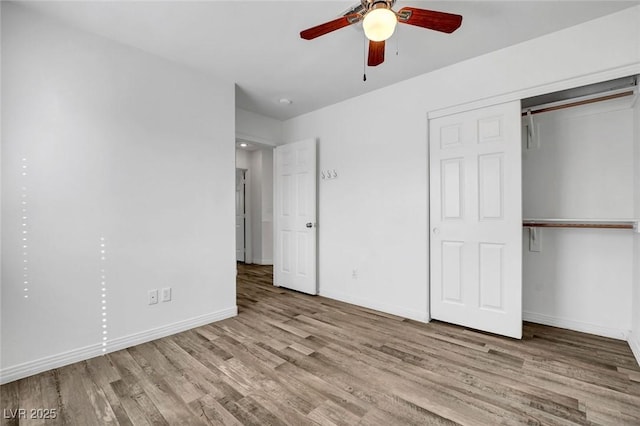 unfurnished bedroom featuring ceiling fan, a closet, and light wood-type flooring