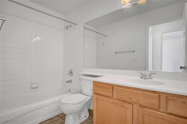 full bathroom featuring vanity, tiled shower / bath combo, tile patterned floors, and toilet