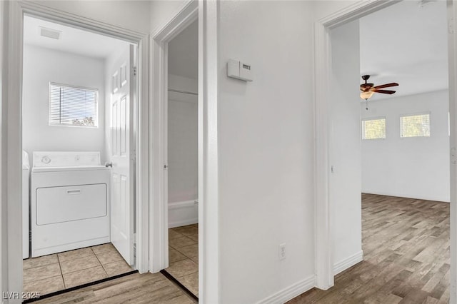 hall with washer / clothes dryer, a wealth of natural light, and light hardwood / wood-style floors