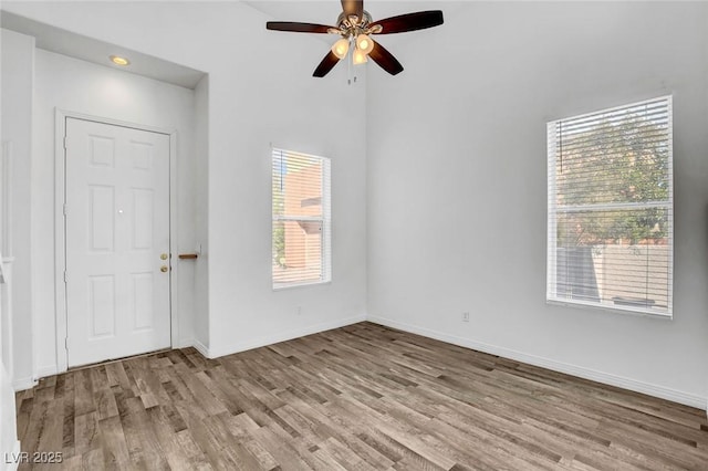 empty room with ceiling fan and light hardwood / wood-style floors