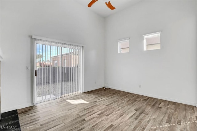 unfurnished room with plenty of natural light, ceiling fan, and light wood-type flooring