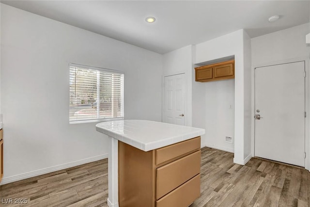 kitchen featuring a center island, tile countertops, and light hardwood / wood-style floors