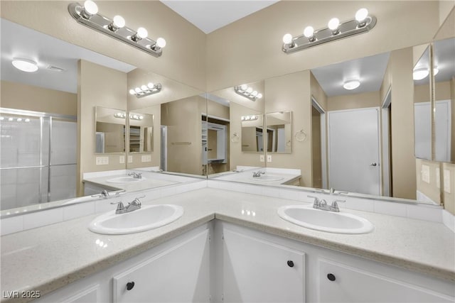 bathroom featuring a shower with door and vanity