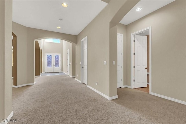 corridor featuring french doors and light carpet