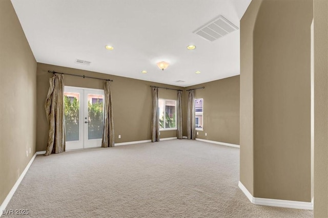 carpeted empty room featuring french doors