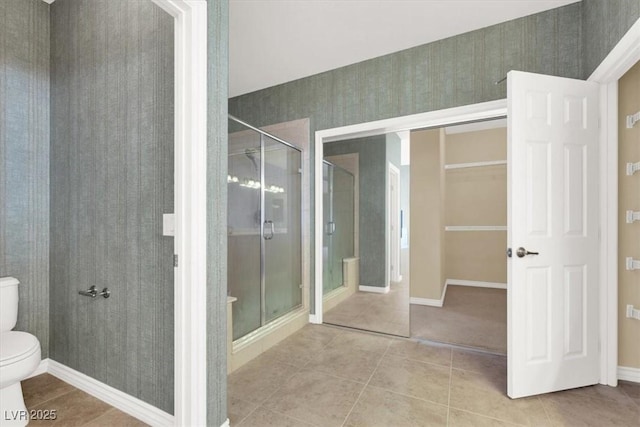 bathroom with a shower with shower door, tile patterned floors, and toilet