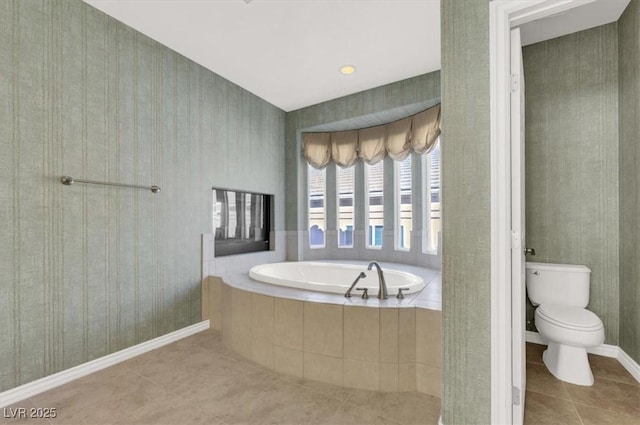 bathroom featuring toilet, tile patterned flooring, and tiled tub